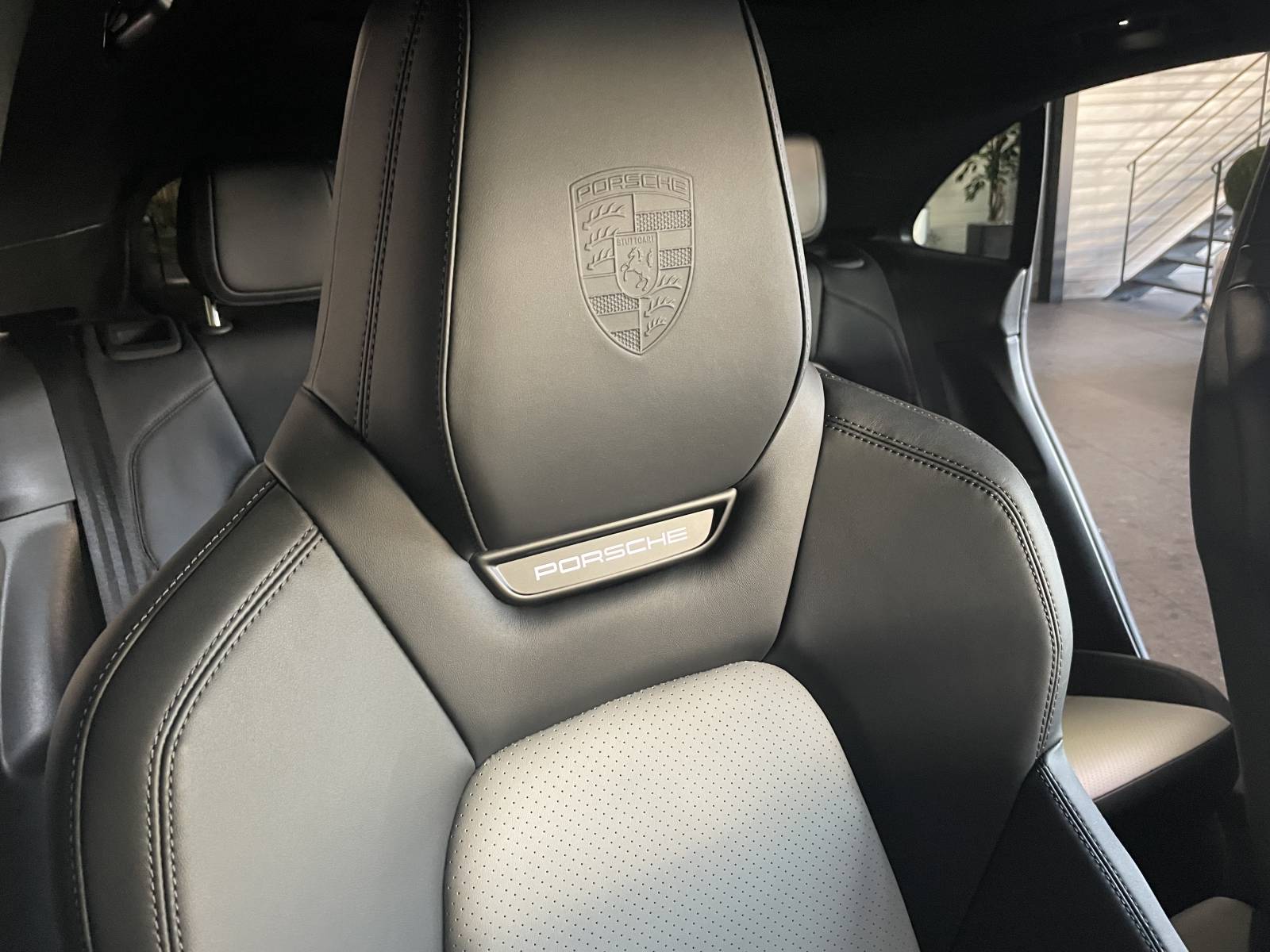 Écusson Porsche sur les appuie-tête de ce Macan II électrique disponible chez MY DREAM CAR.