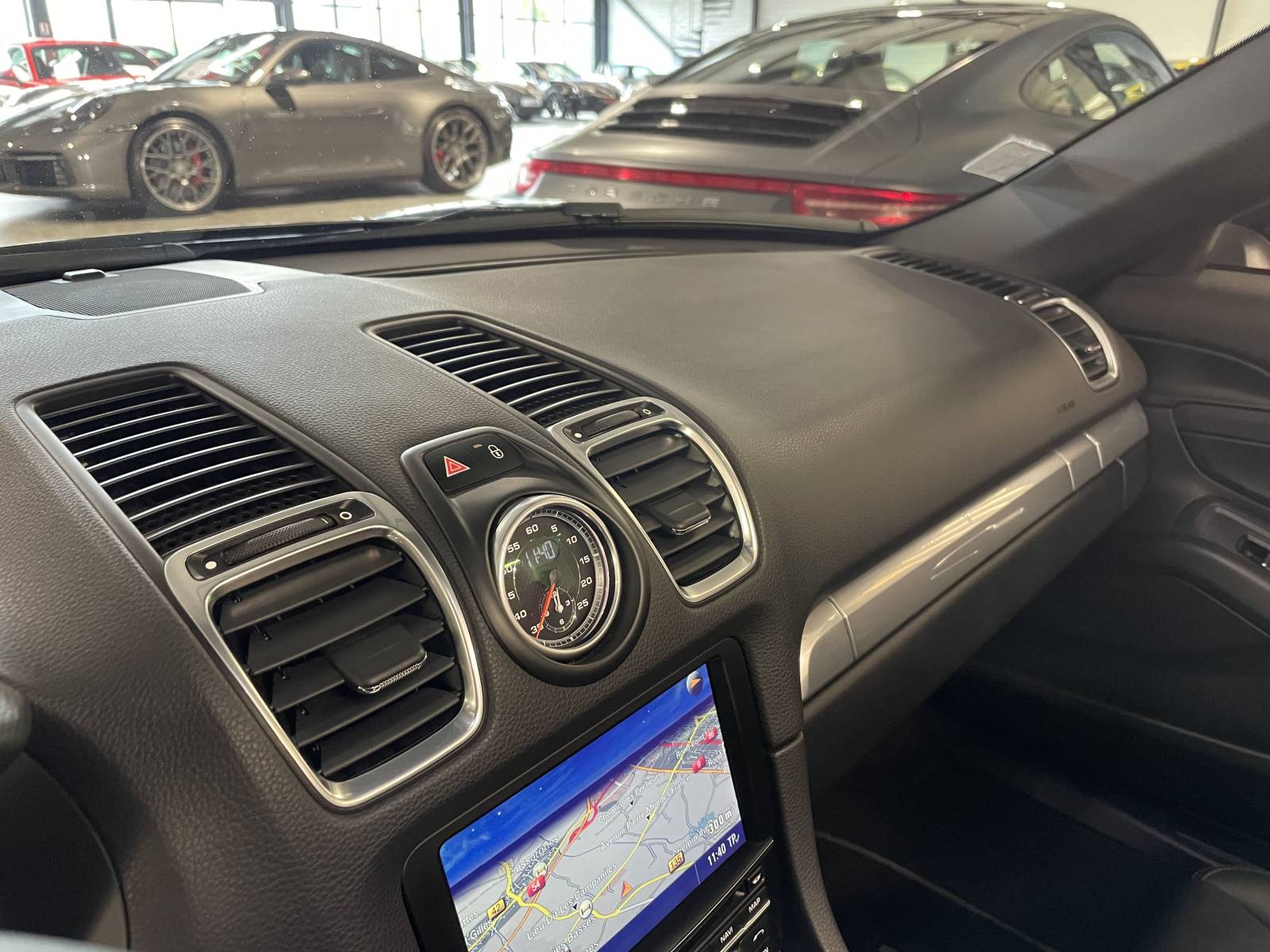 Intérieur cockpit : Habitacle sport Porsche avec volant cuir et finition alu.