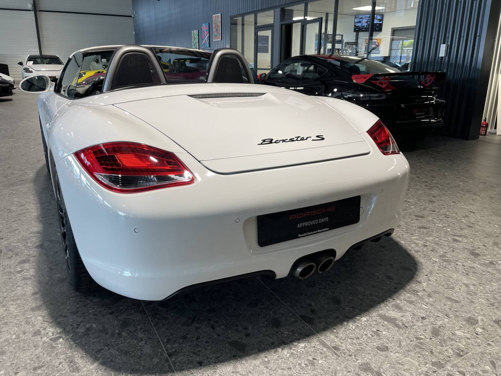 Vue ¾ arrière : Échappement sport et becquet escamotable, l'ADN Porsche à Nîmes.