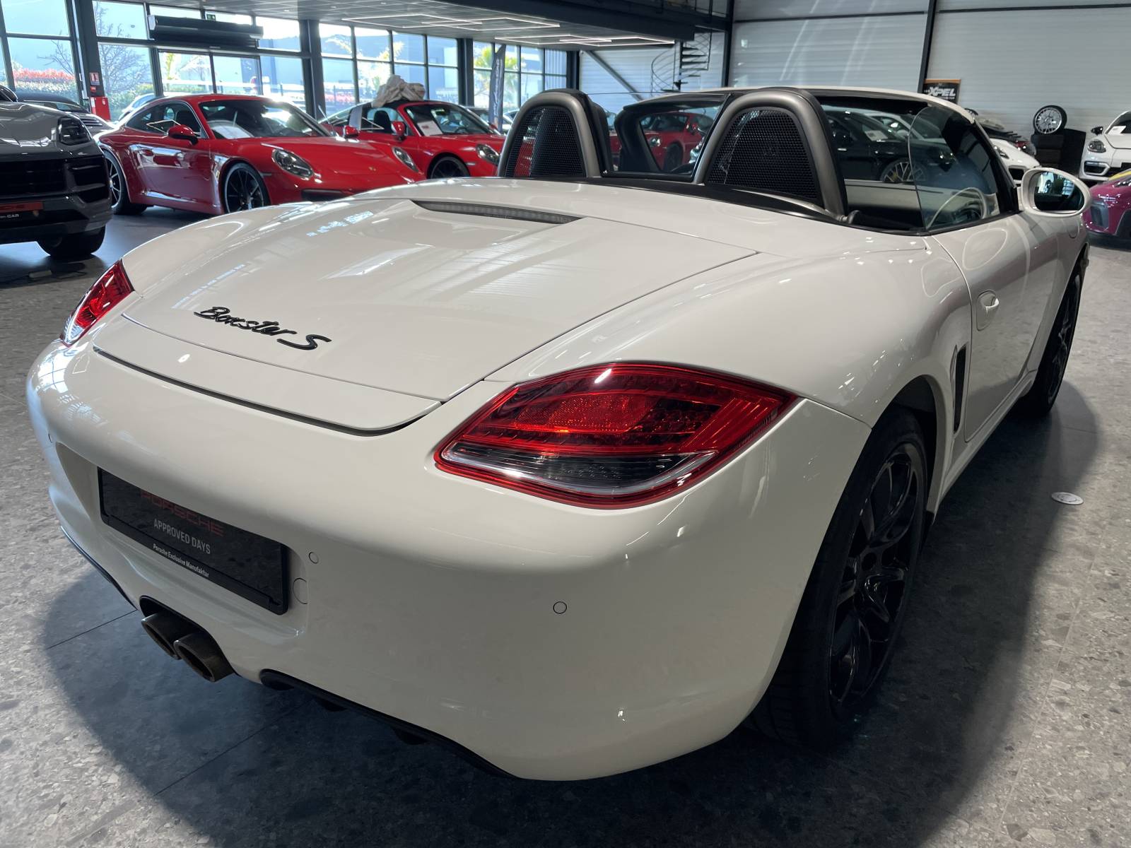 Vue ¾ arrière : Échappement sport et becquet escamotable, l'ADN Porsche à Nîmes.