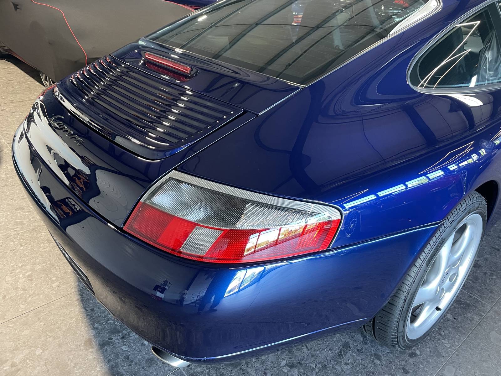 Vue de trois-quart arrière : Arrière large et sorties chromées Porsche 911 Carrera 996.