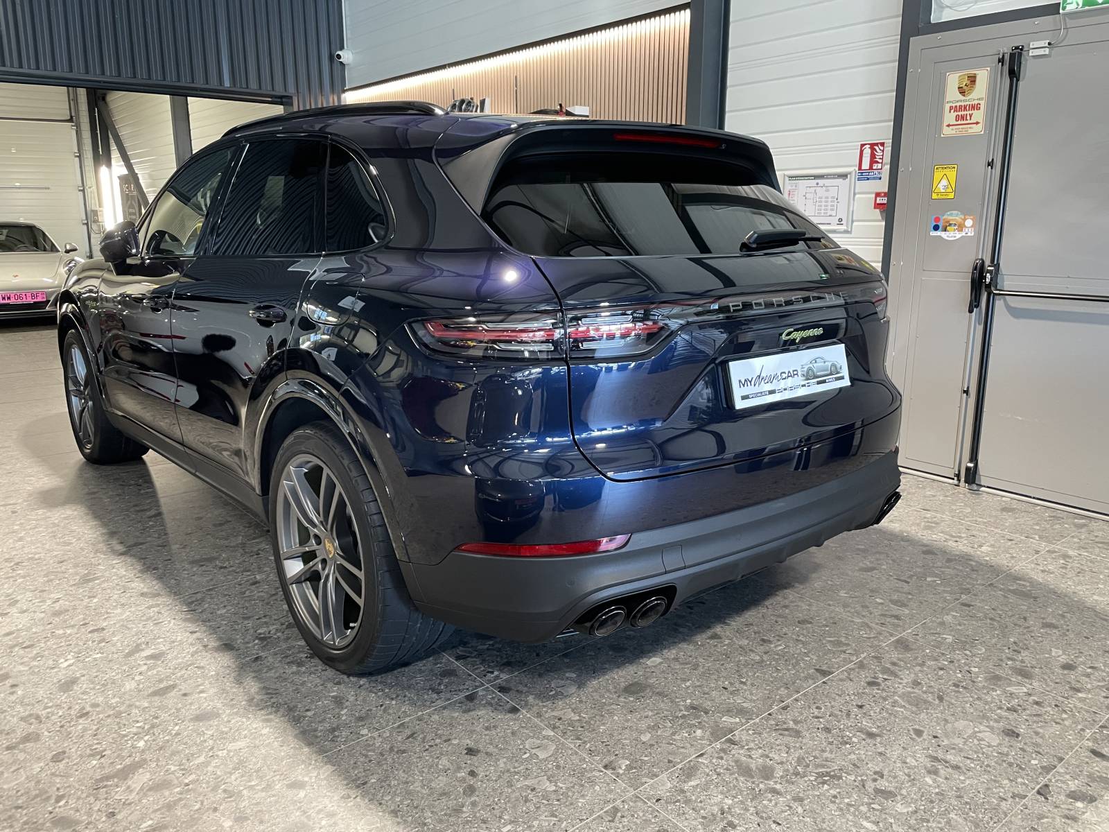 Vue de trois-quarts arrière : SUV Porsche Cayenne 462 ch avec feux LED teintés et bandeau lumineux.