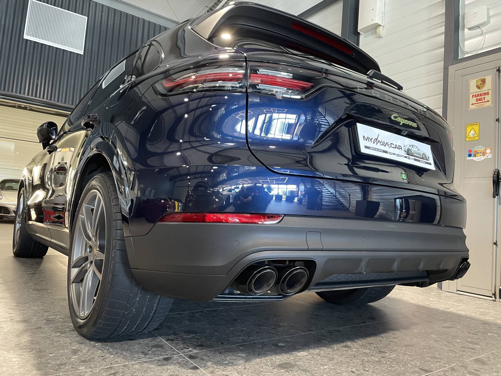 Vue de trois-quarts arrière : SUV Porsche Cayenne 462 ch avec feux LED teintés et bandeau lumineux.