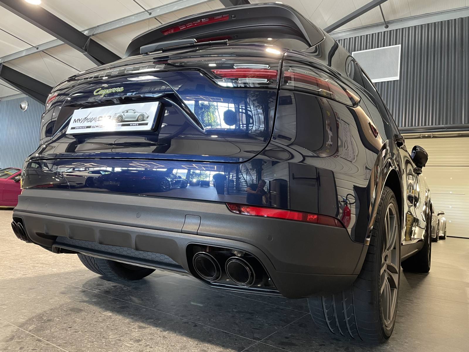 Vue de trois-quarts arrière : SUV Porsche Cayenne 462 ch avec feux LED teintés et bandeau lumineux.