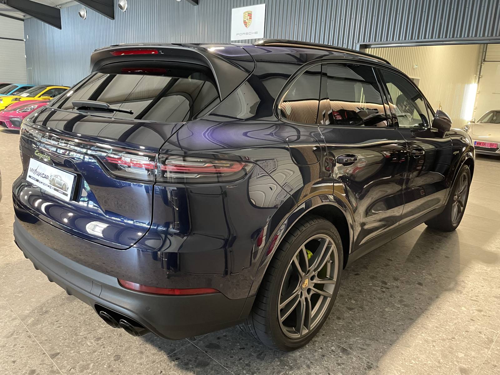 Vue de trois-quarts arrière : SUV Porsche Cayenne 462 ch avec feux LED teintés et bandeau lumineux.