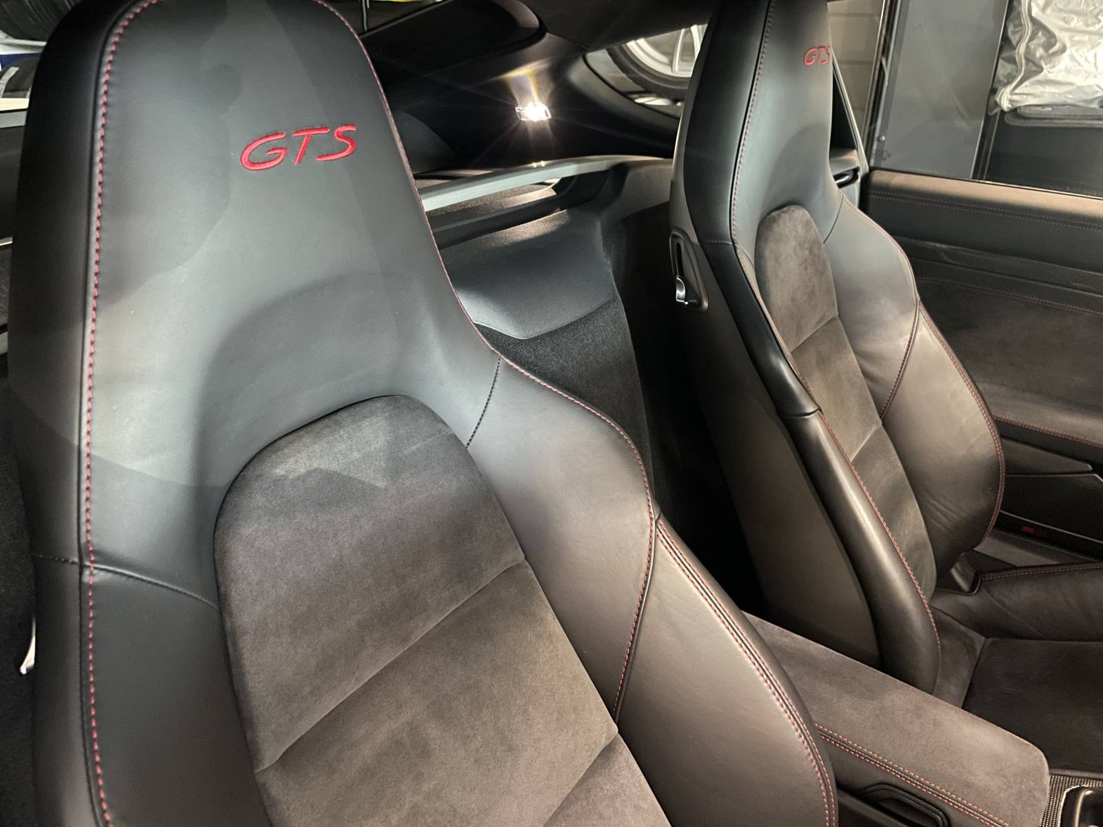 Appuis-tête brodés du logo GTS sur les sièges baquets de la Porsche Cayman 3.4 GTS d'occasion dans le Vaucluse.