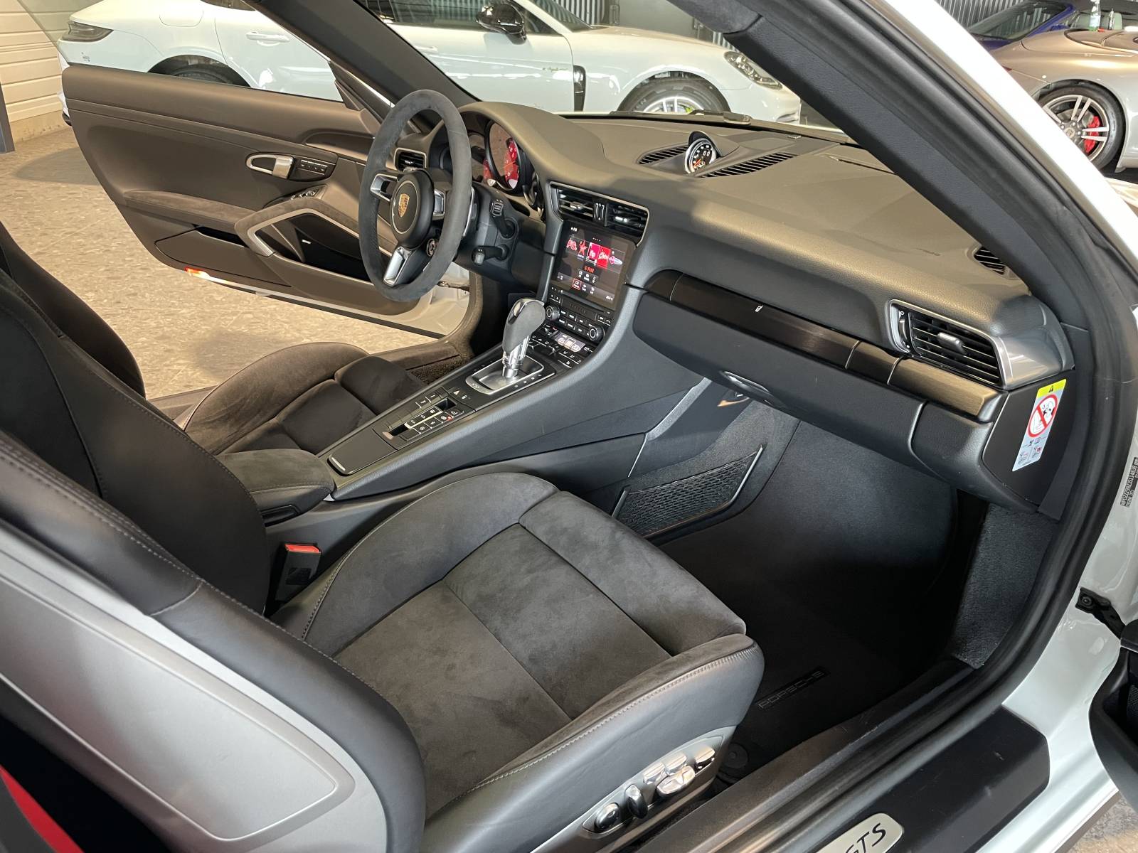 Vue plongeante sur l'élégance et la sportivité de cette Porsche 911 Carrera 4 GTS occasion en attente d'achat.